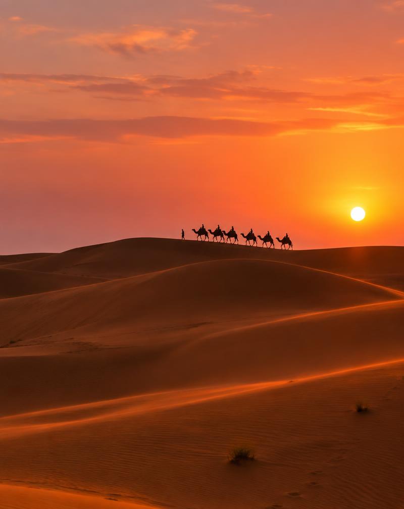 A camel caravan crossing the dunes of Erg Chebbi at sunset